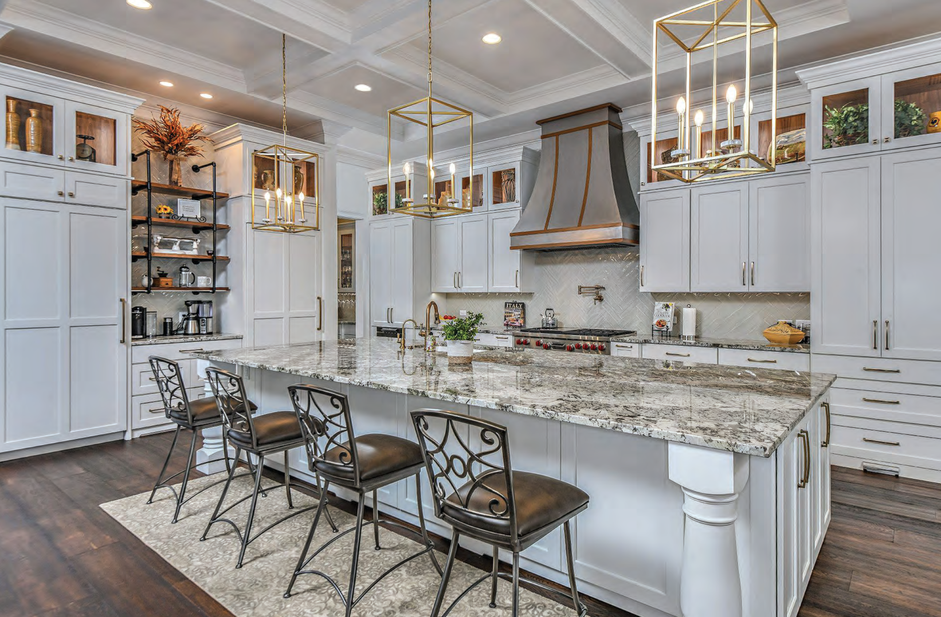 A kitchen with white cabinets, granite counter tops, and a large island.