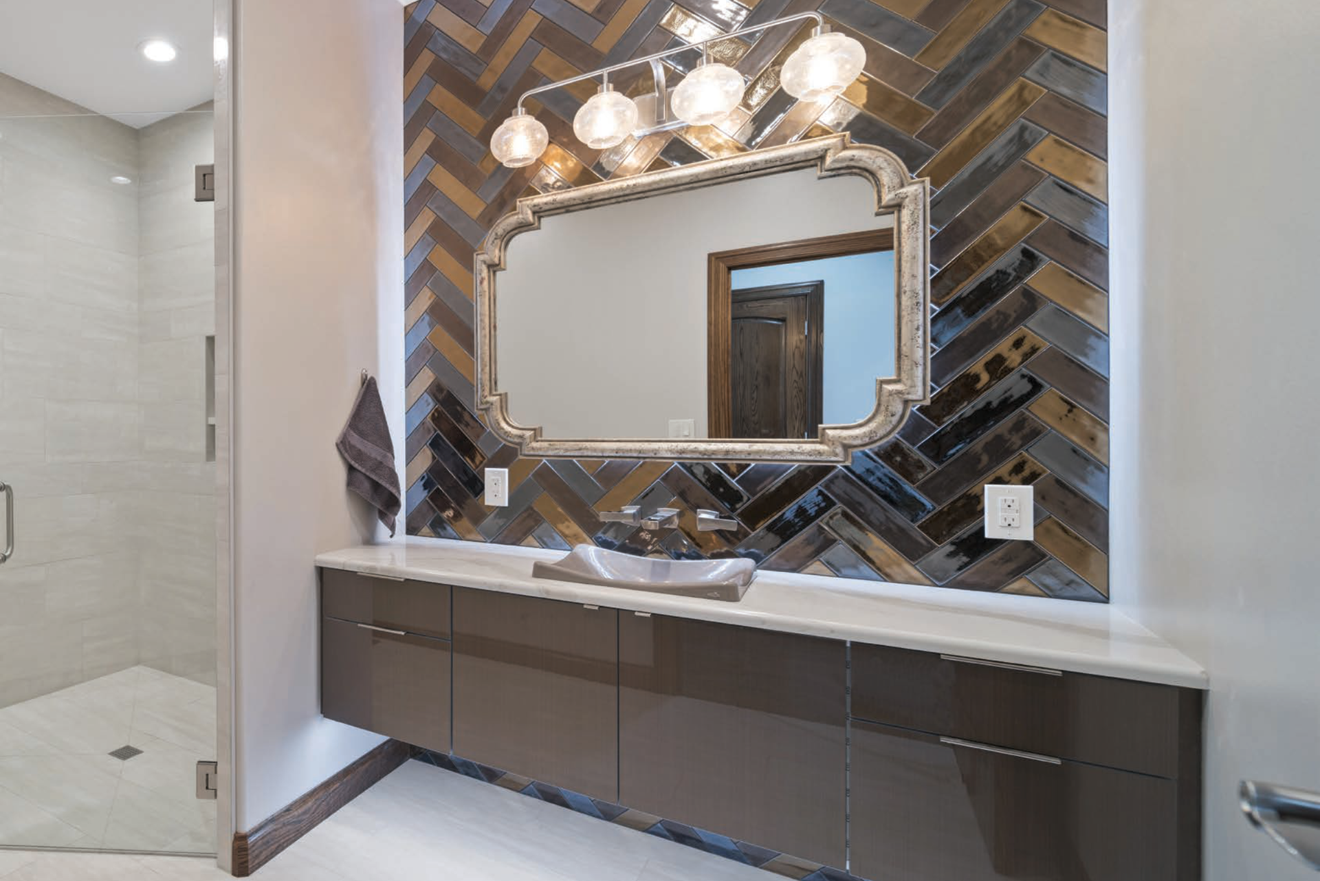 A bathroom with a sink, mirror, and shower.