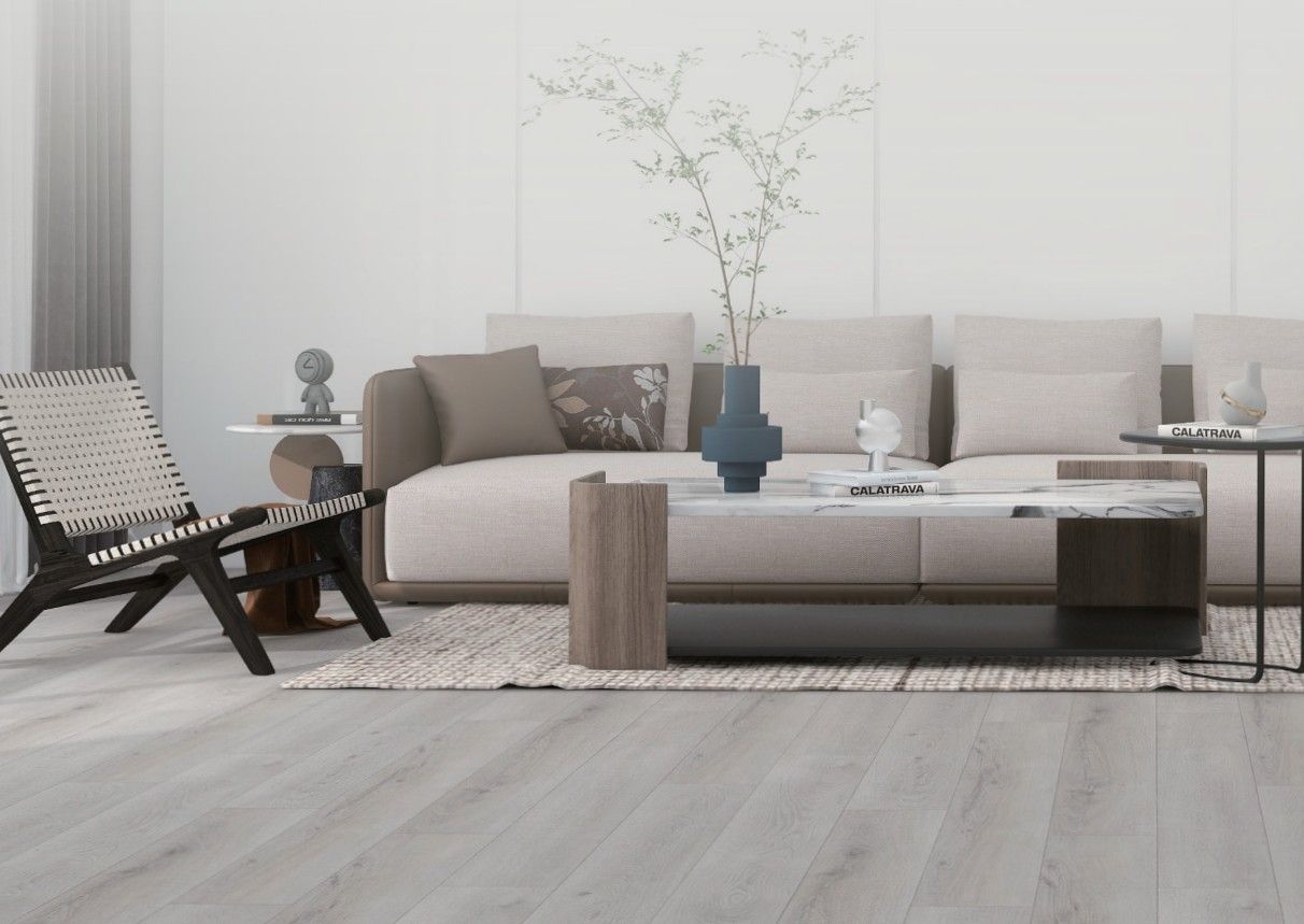 A bright, modern living room with a beige sofa, patterned accent chair, marble coffee table, and light wood-look flooring.