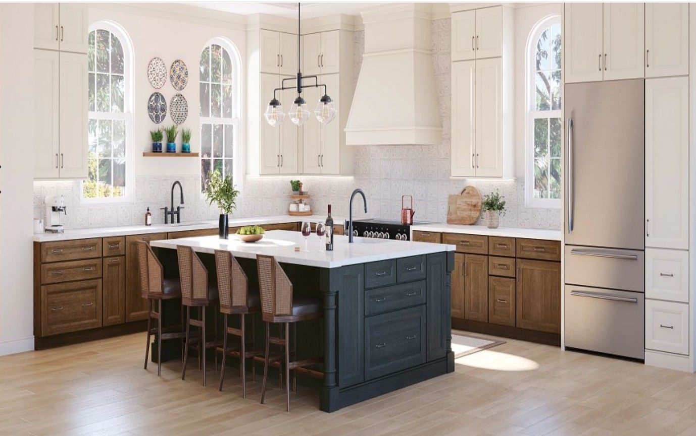 A modern kitchen with a dark-colored island, light wood lower cabinets, white upper cabinets, and stainless steel appliances.