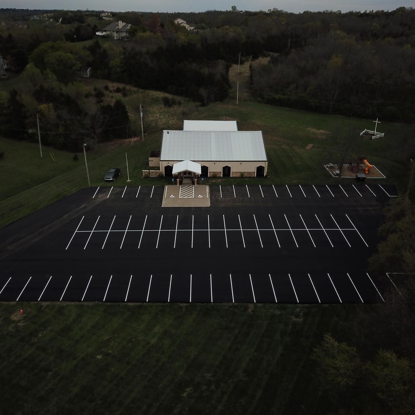An aerial view of a parking lot with a building in the background