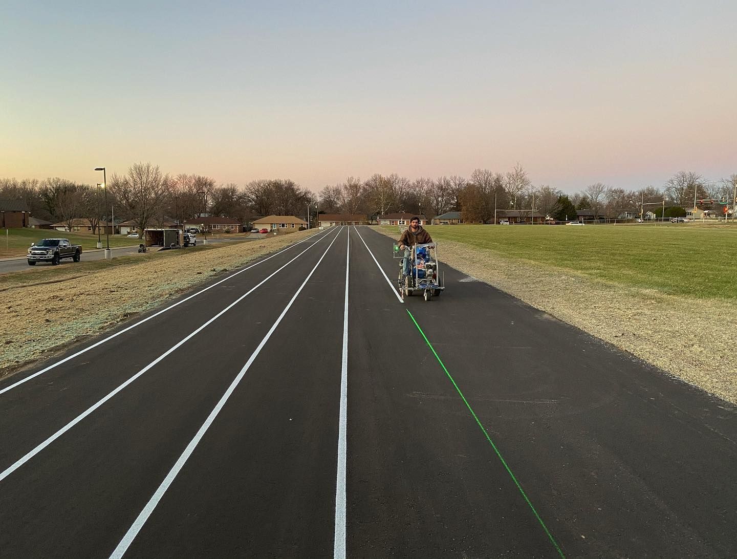 A man is laying down markings on a road