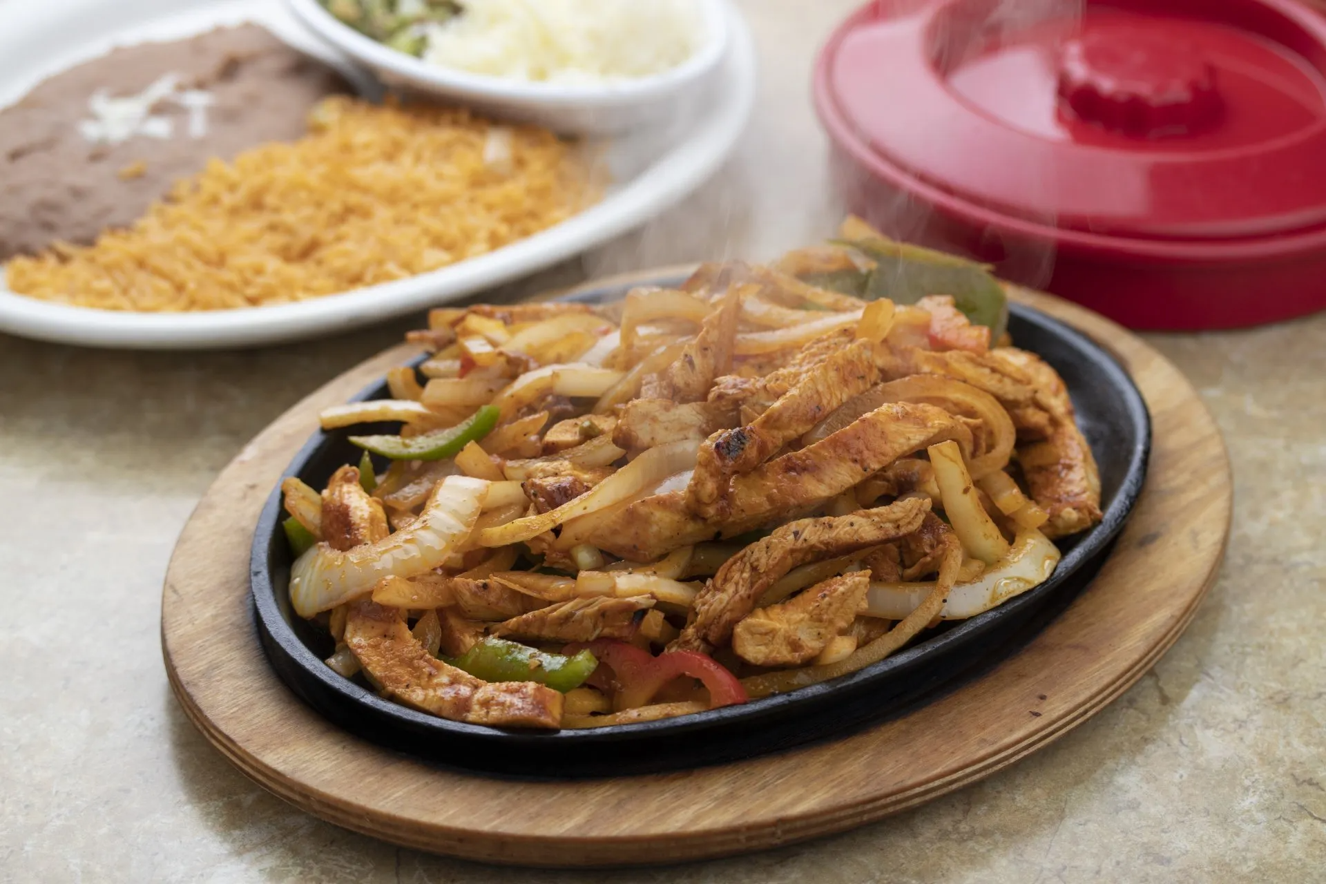 A plate of food is sitting on a wooden cutting board on a table.