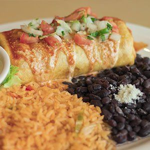 A burrito , rice , and black beans on a plate.
