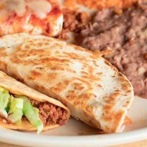 A close up of a plate of food with quesadillas and beans.