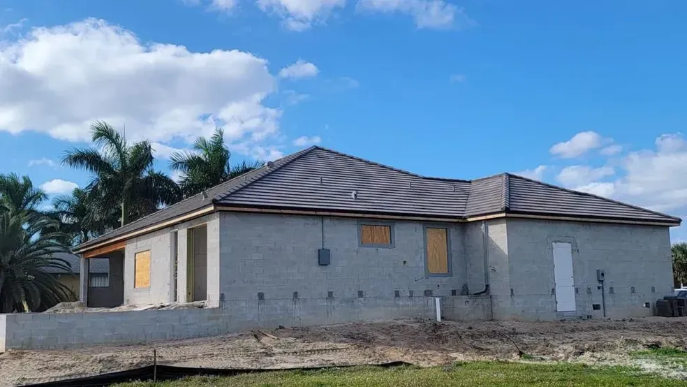 A house is being built in the middle of a dirt field.