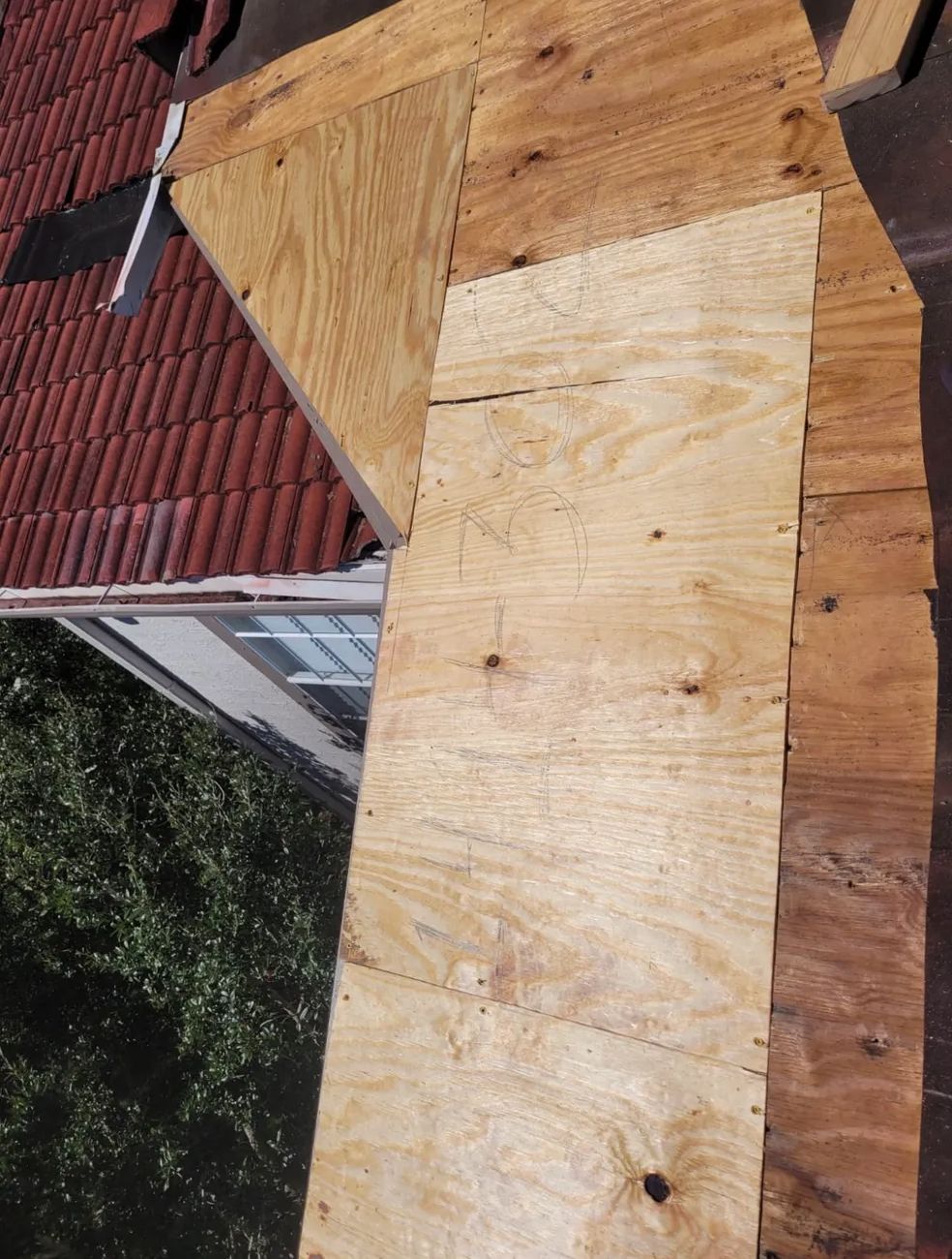 A large piece of wood is sitting on top of a roof.