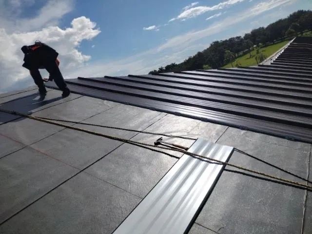 A man is working on the roof of a building