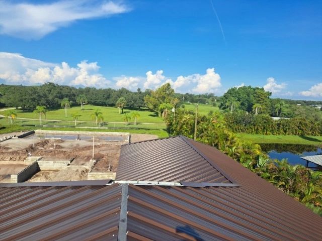 An aerial view of a roof with a golf course in the background
