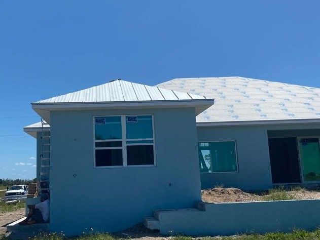 A blue house with a white roof is being built.