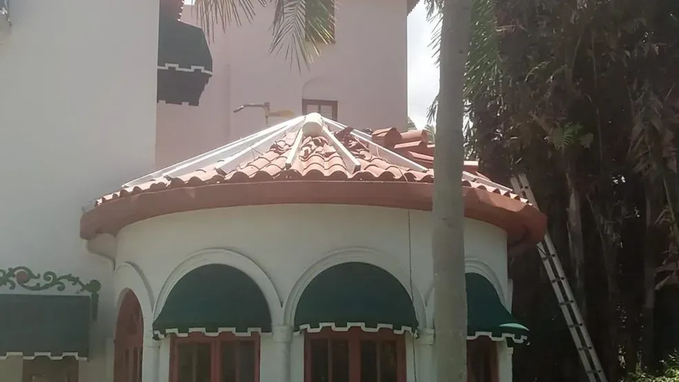 A house with a dome roof and awnings on the windows.