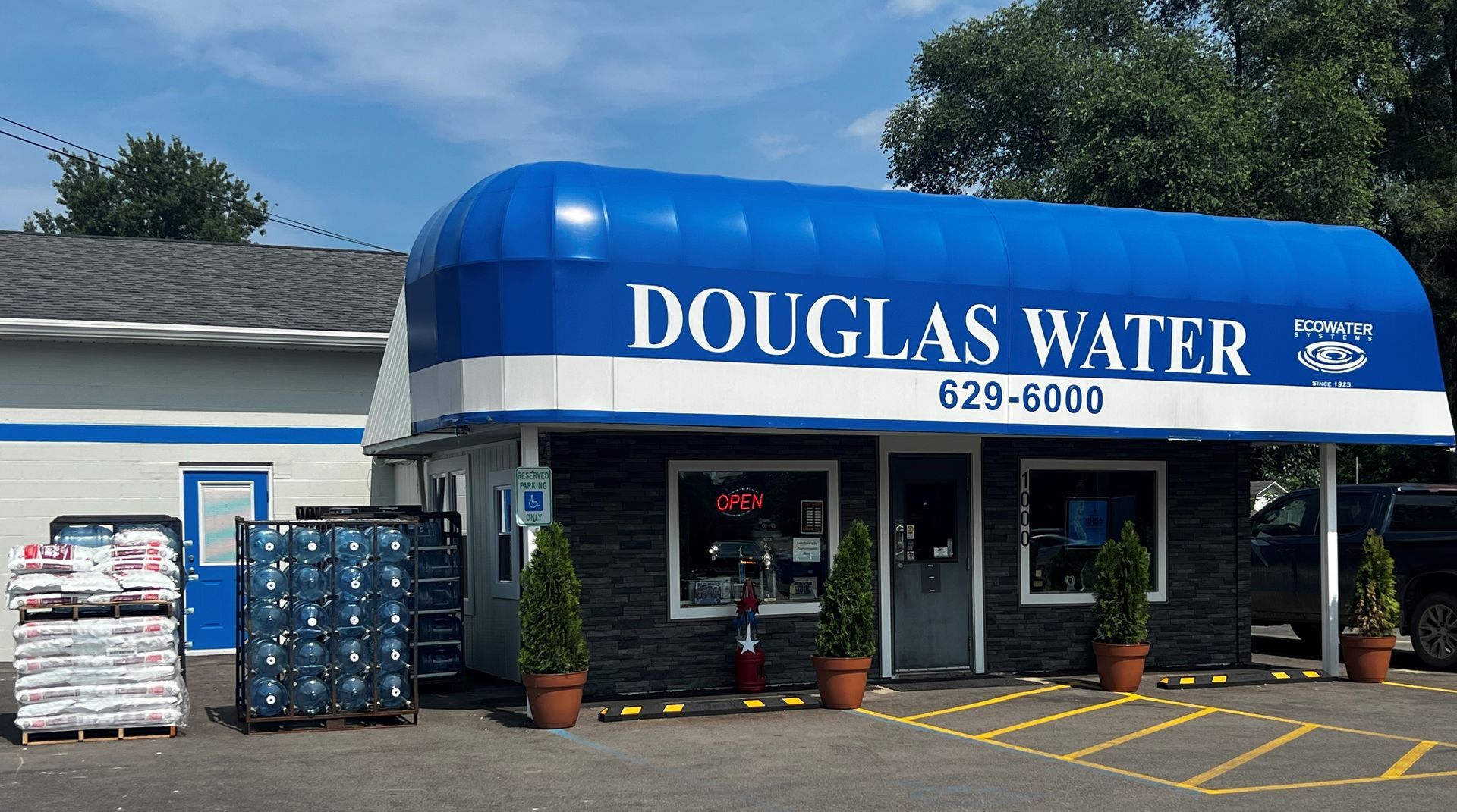 a store front with a blue awning that says douglas water