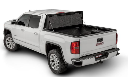 White GMC pickup truck with a black, folding bed cover. The cover is open, revealing the truck bed.