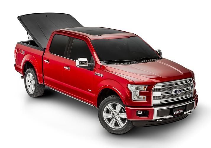 Red Ford F-150 truck with a black tonneau cover open, parked on a white background.