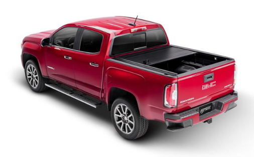 Red GMC truck with a retractable tonneau cover, angled view.
