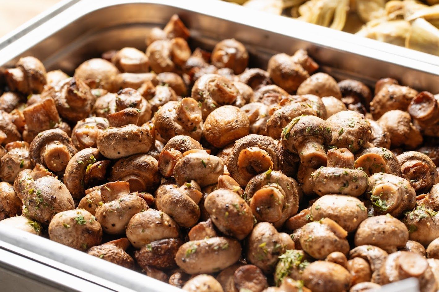Tray of seasoned roasted mushrooms in a metal pan