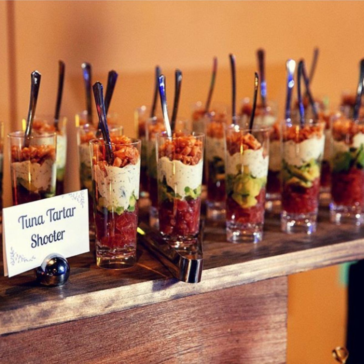 A display of food with a sign that says tuna tartar shooter.