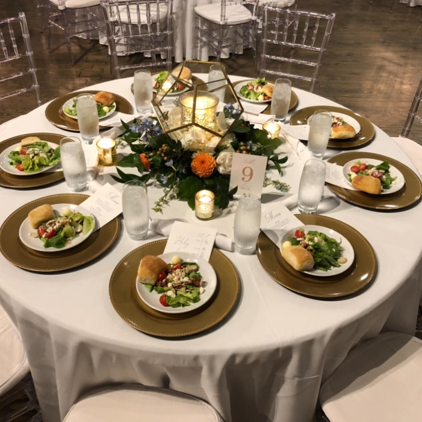A table with plates of food and candles and the number 9 on it.