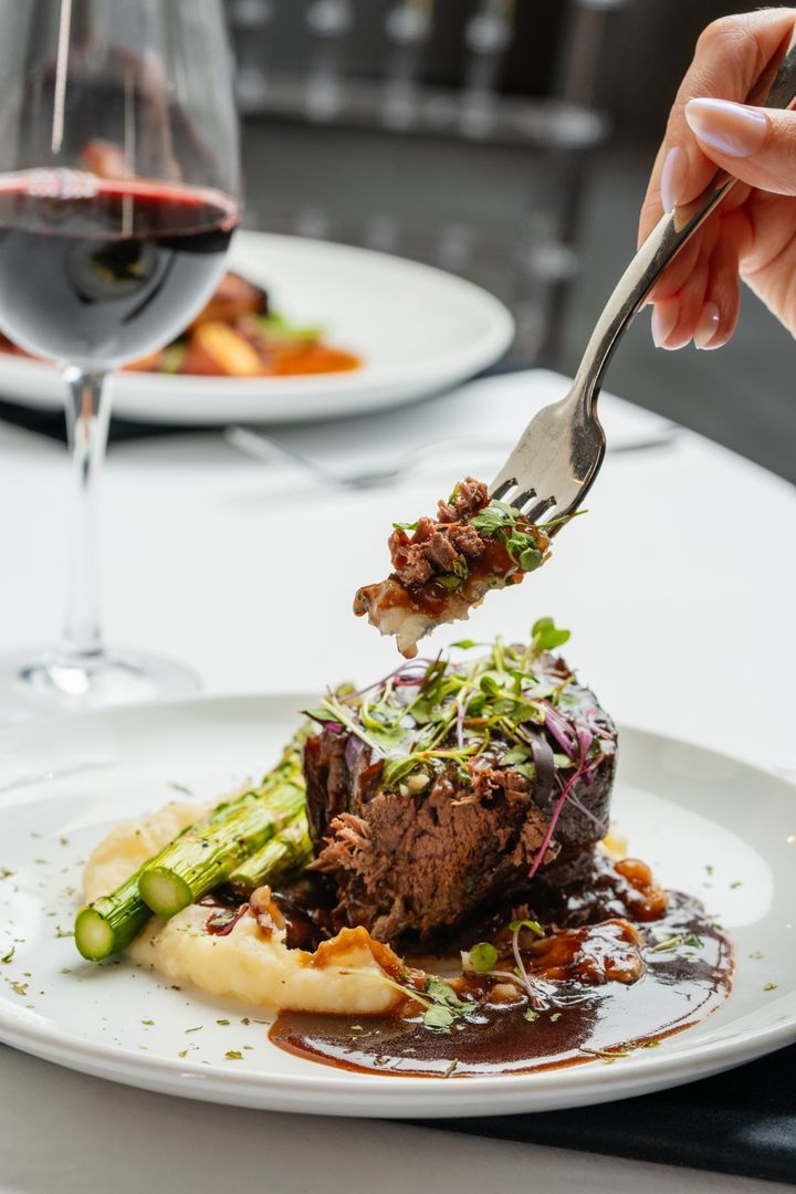 A person is holding a fork over a plate of food.
