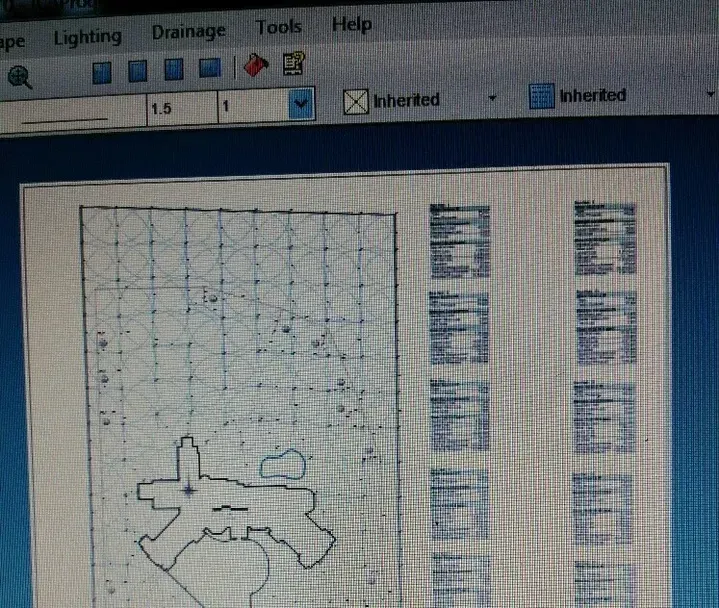A computer screen displays a blueprint-like grid map with annotations and several rectangular panels on the right.