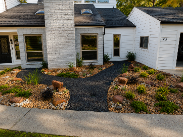 Before and after photos of a house exterior; the before photo has a lawn, the after has a stone pathway and landscaping.