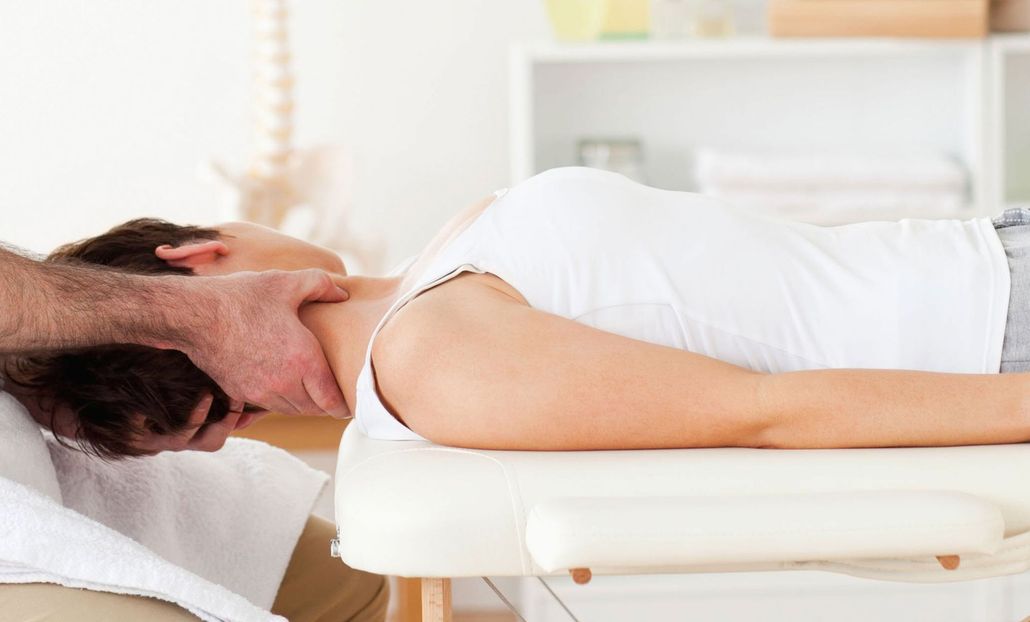 Person lying on a massage table with head turned to the side.