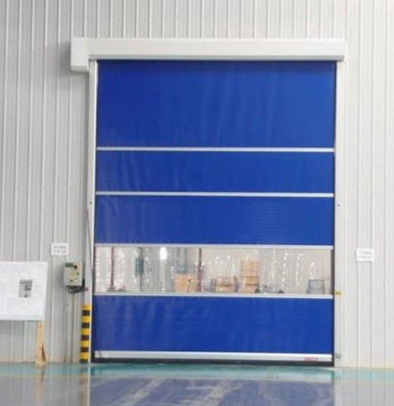 Blue industrial rolling door with a horizontal transparent viewing strip in a warehouse-like interior