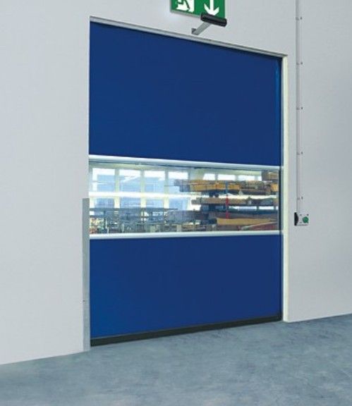 Blue industrial roll-up door with a narrow glass window in a white hallway.