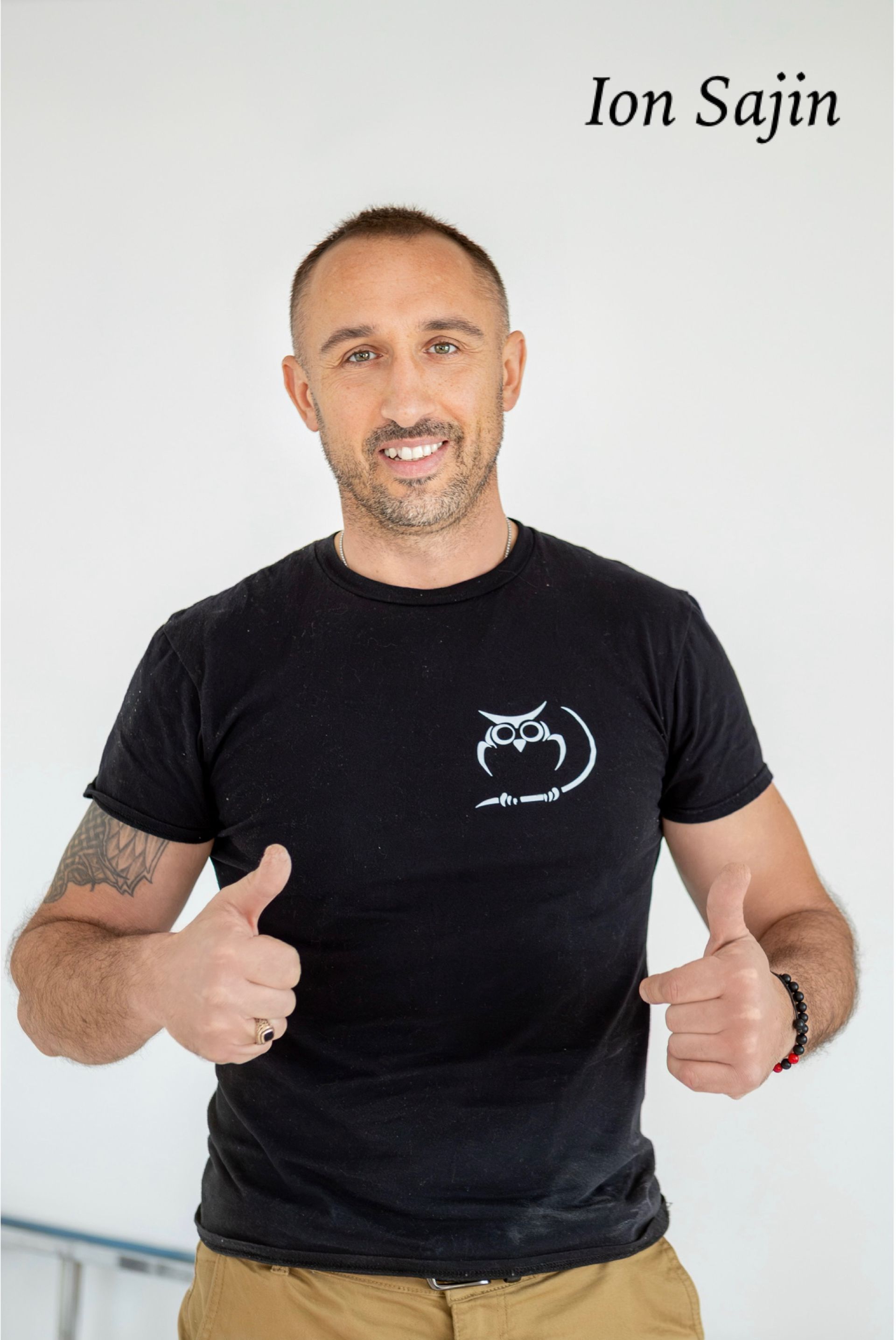 Man in black t-shirt giving thumbs up, smiling. Text 