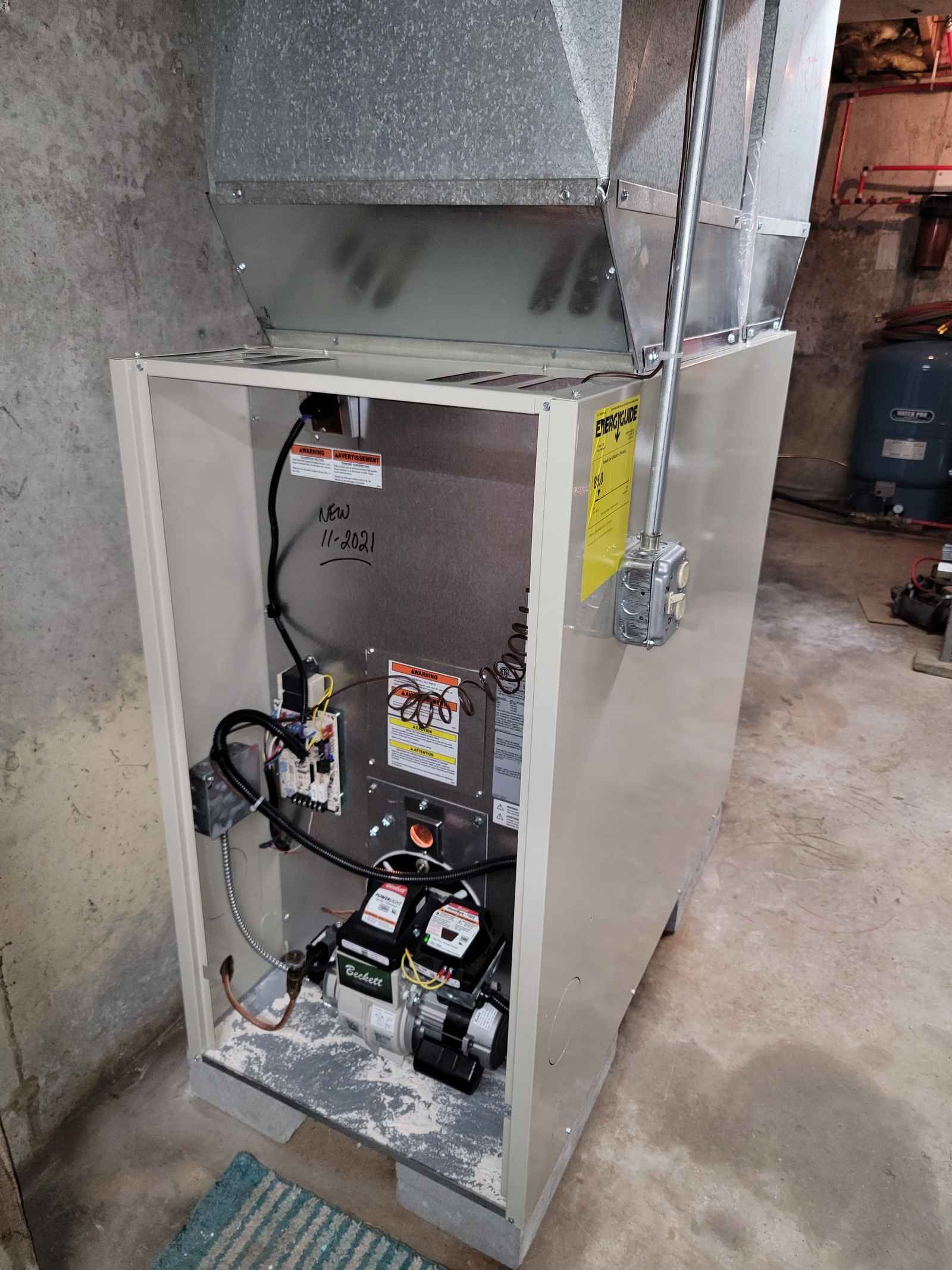 An air conditioner is sitting in a basement with the door open.