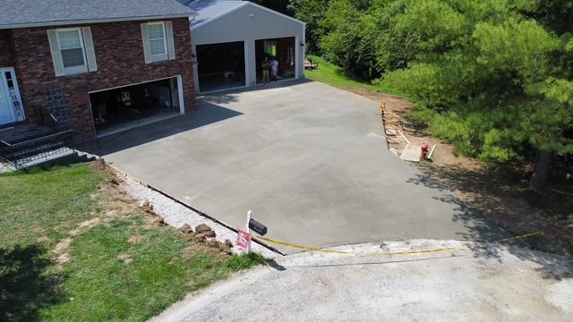 Newly poured concrete driveway with home and detached garage.