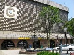 A large building with a white car parked in front of it.