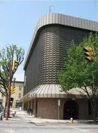 A large building is sitting on the corner of a city street.