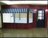 An empty room with a striped awning over a window.
