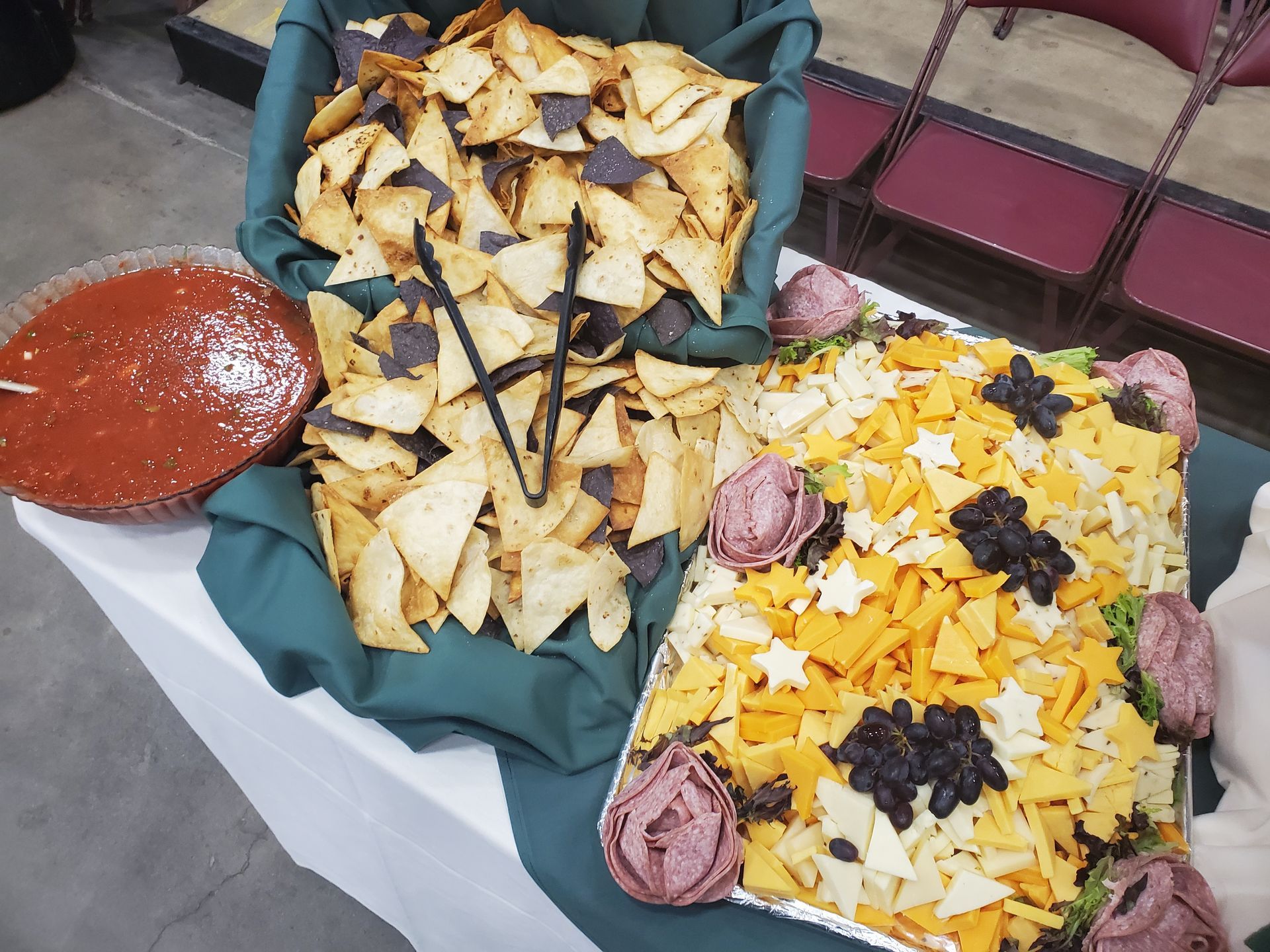 a table topped with tortilla chips , cheese and salsa .