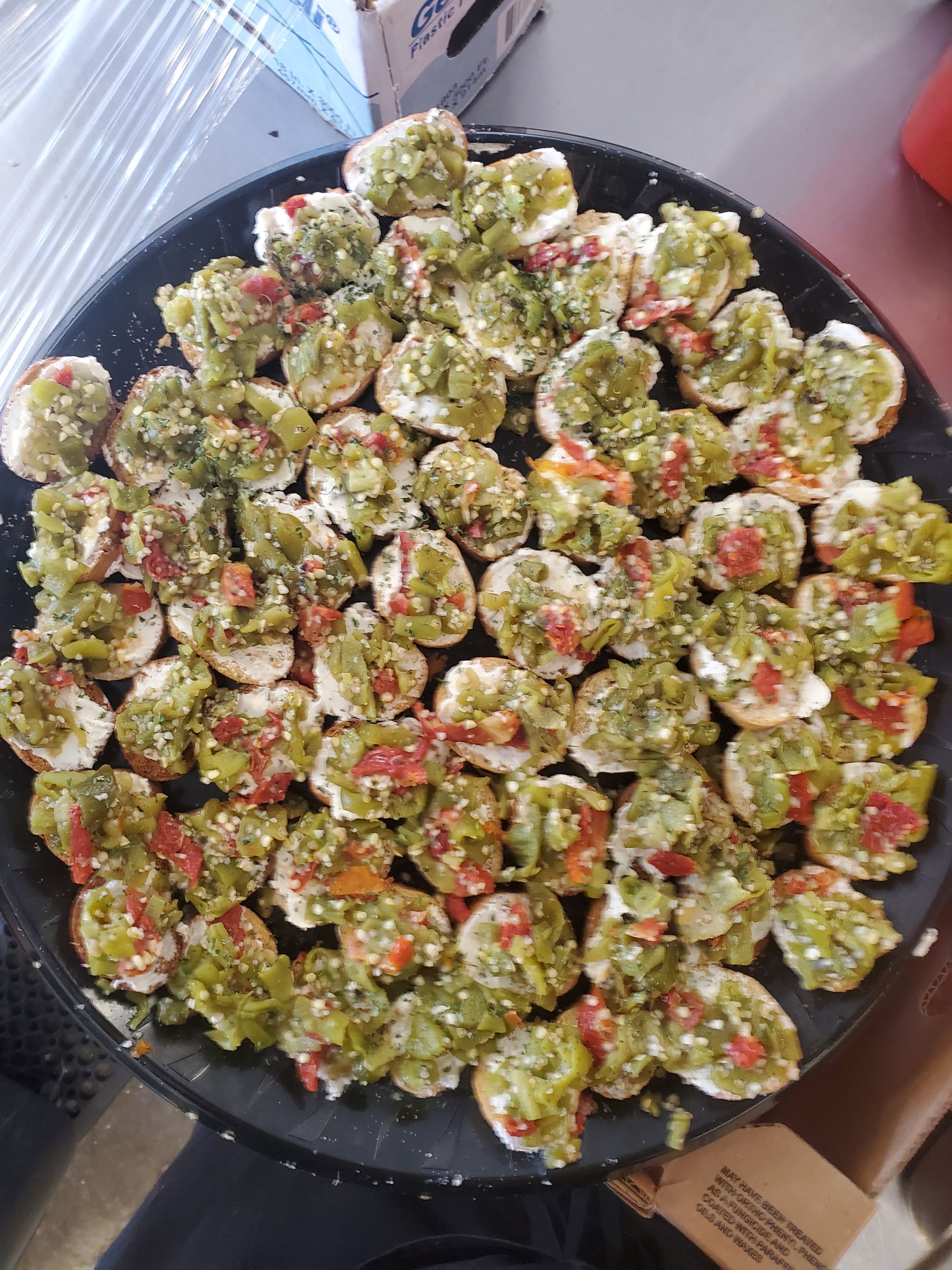 a black plate filled with green and red vegetables