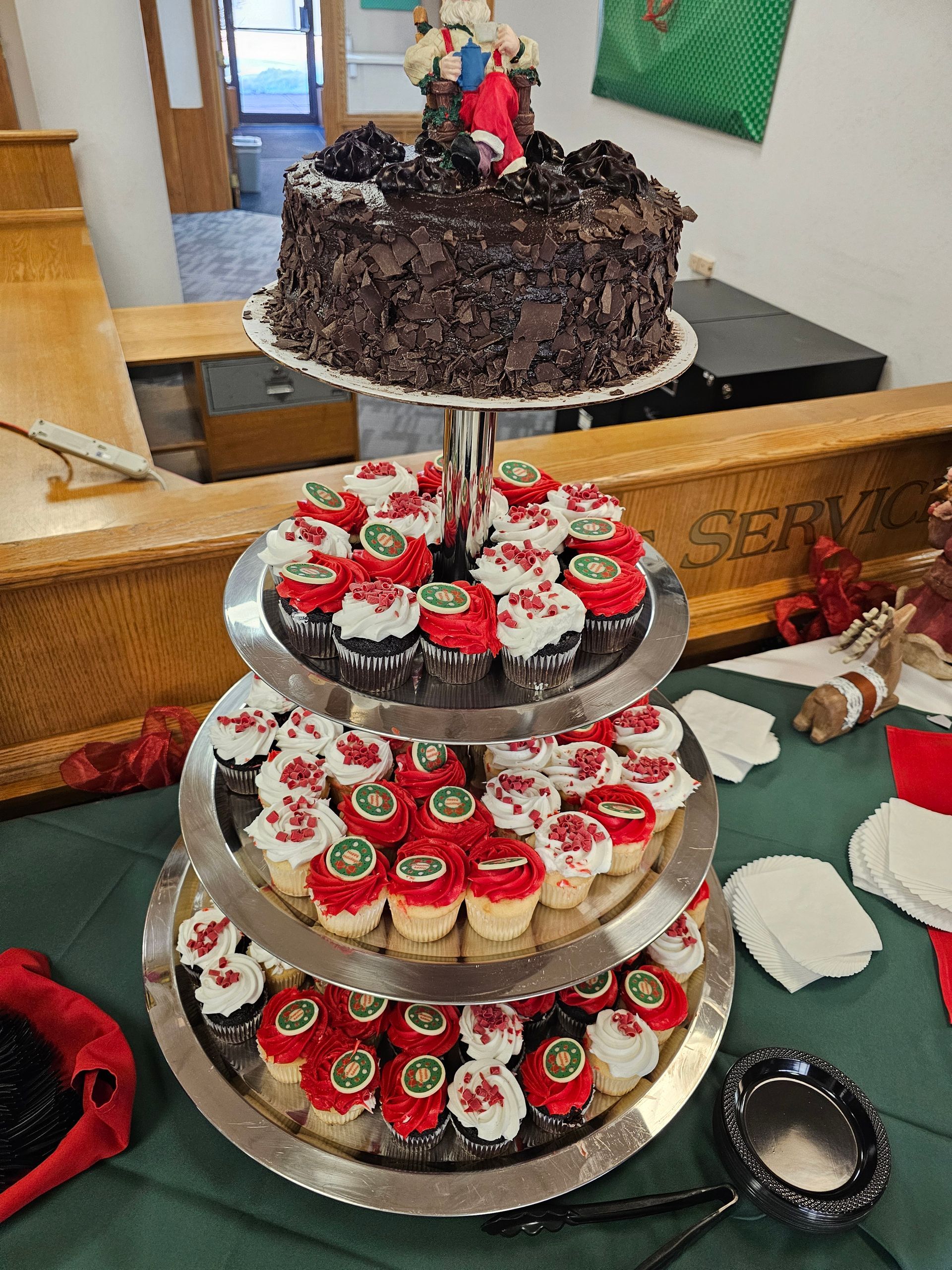 a stack of cupcakes and a cake on a table .