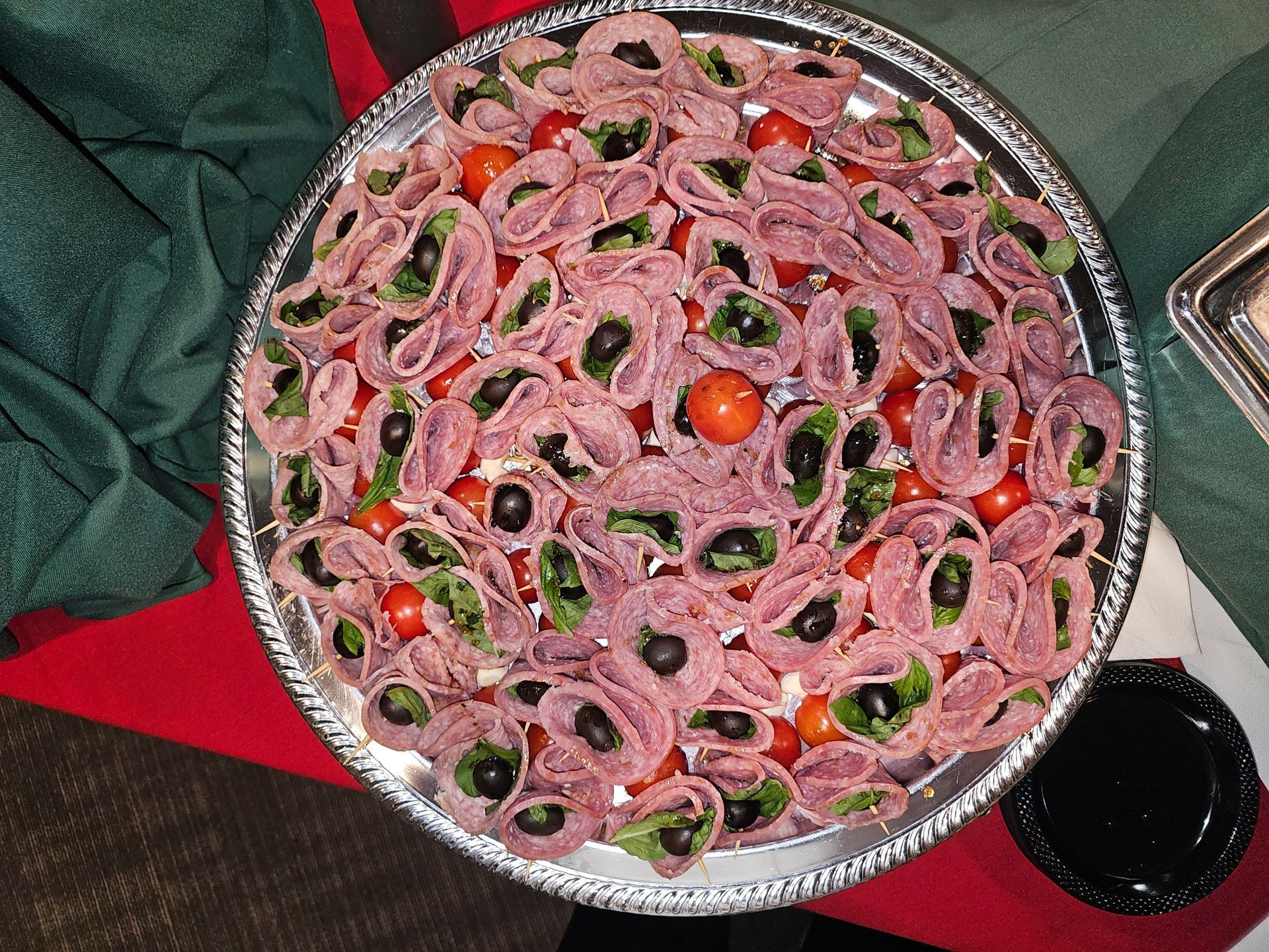 a silver tray filled with meat olives and tomatoes