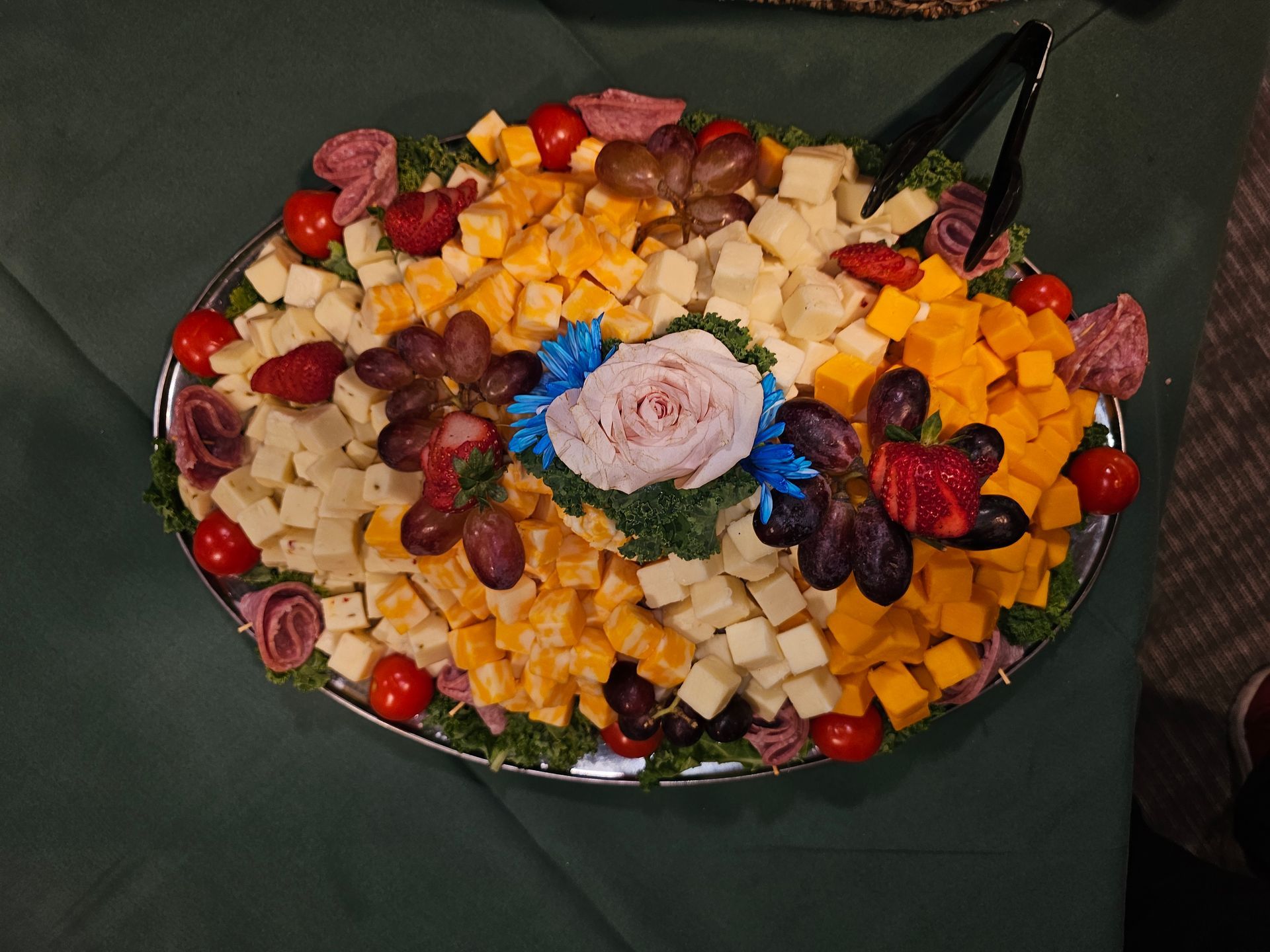 a tray of cheese tomatoes and grapes on a table