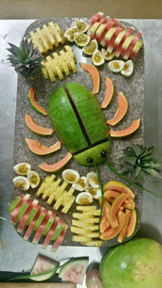 a cutting board with fruit arranged in the shape of a bug .