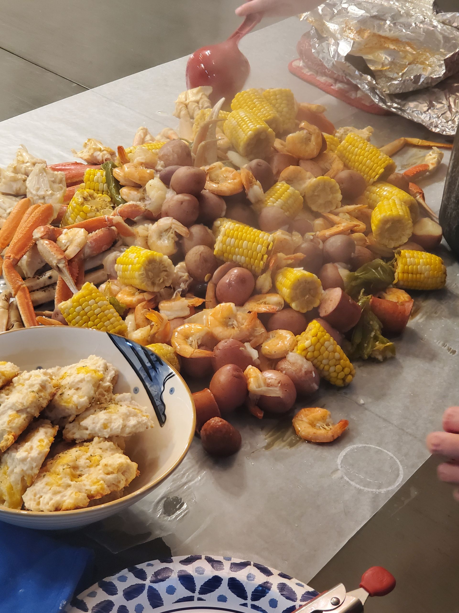a table topped with a variety of food including shrimp corn and potatoes