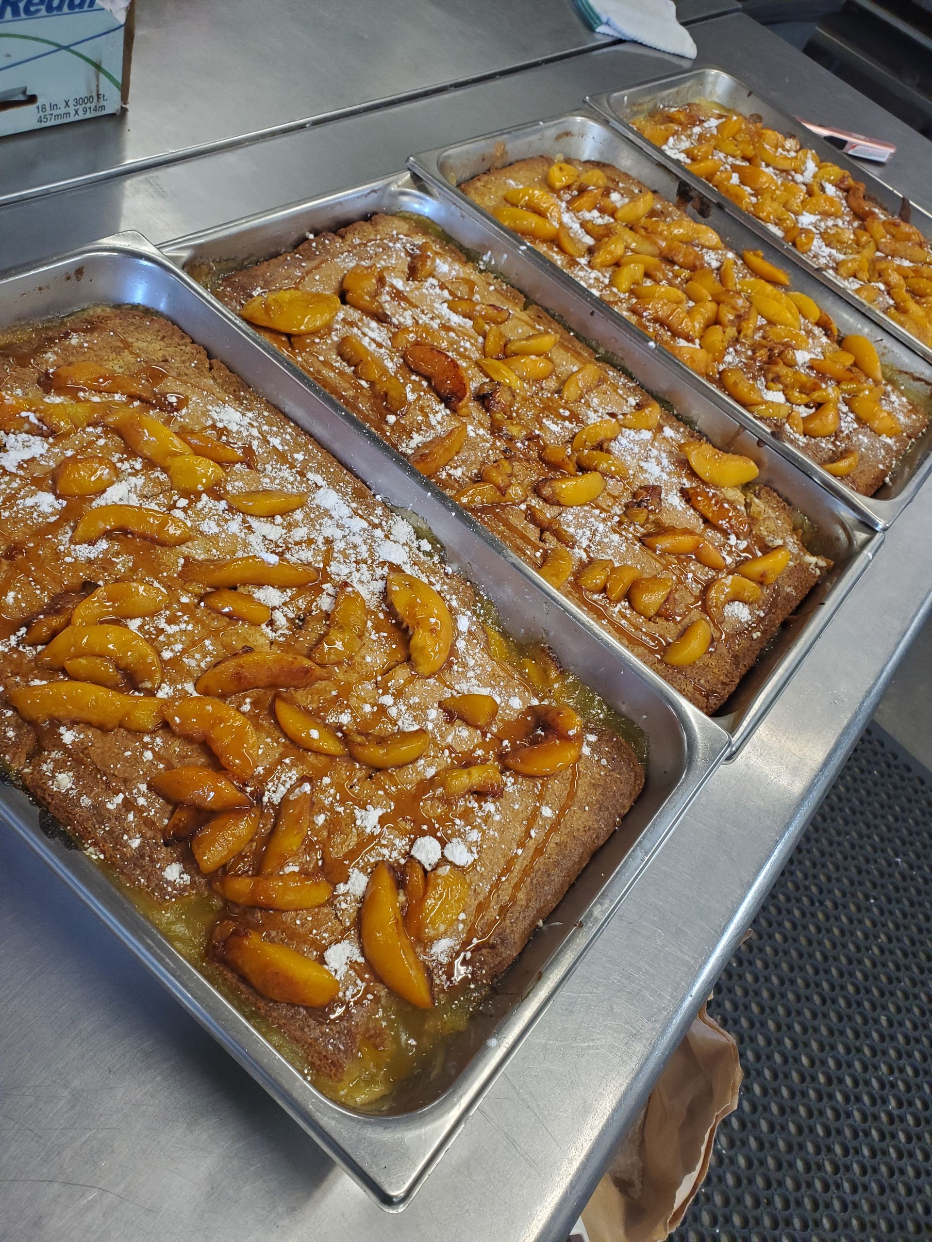 a bunch of pans of food with peaches on them