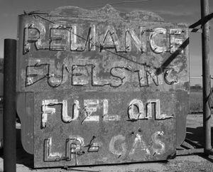 Weathered sign listing fuel types: gasoline, fuel oil, and LP gas.