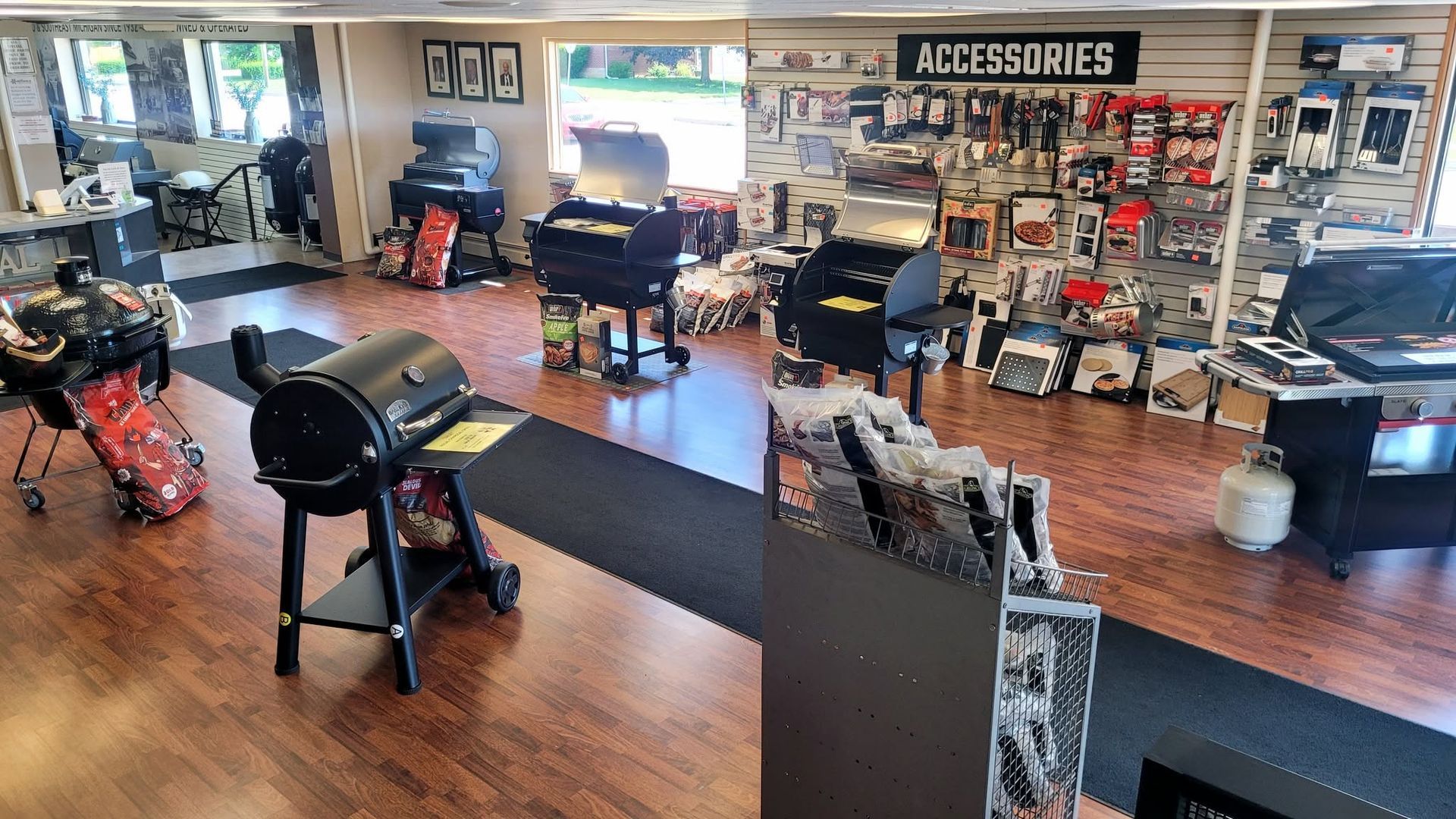 Empty motorcycle showroom with accessories displays, bikes, and polished wooden floors.