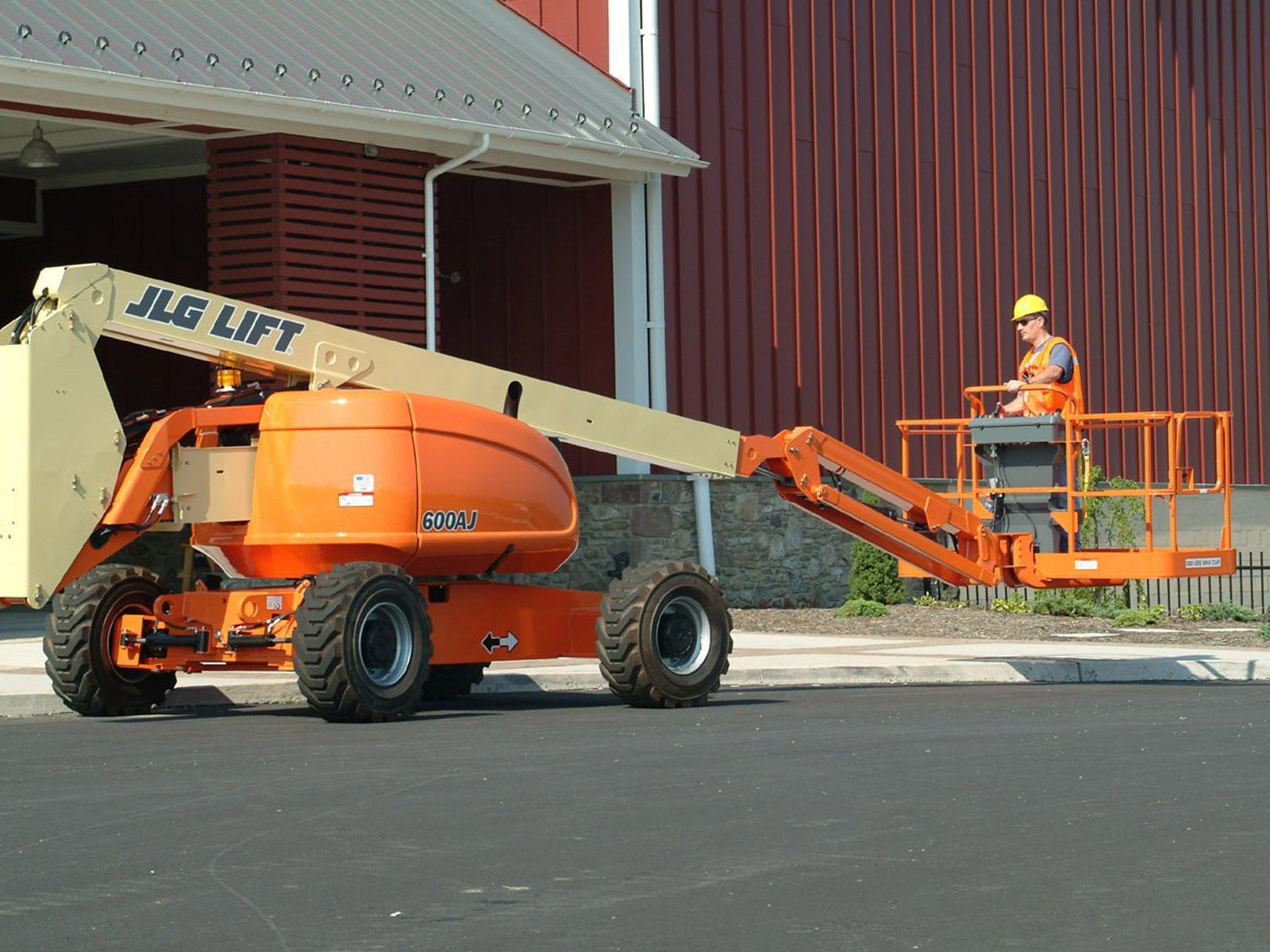 A jlg lift is parked in front of a building
