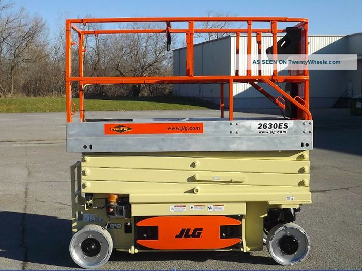 A jlg scissor lift is parked in a parking lot
