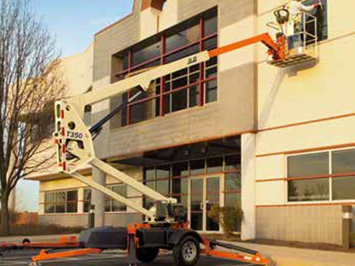 A man is painting a window on the side of a building.