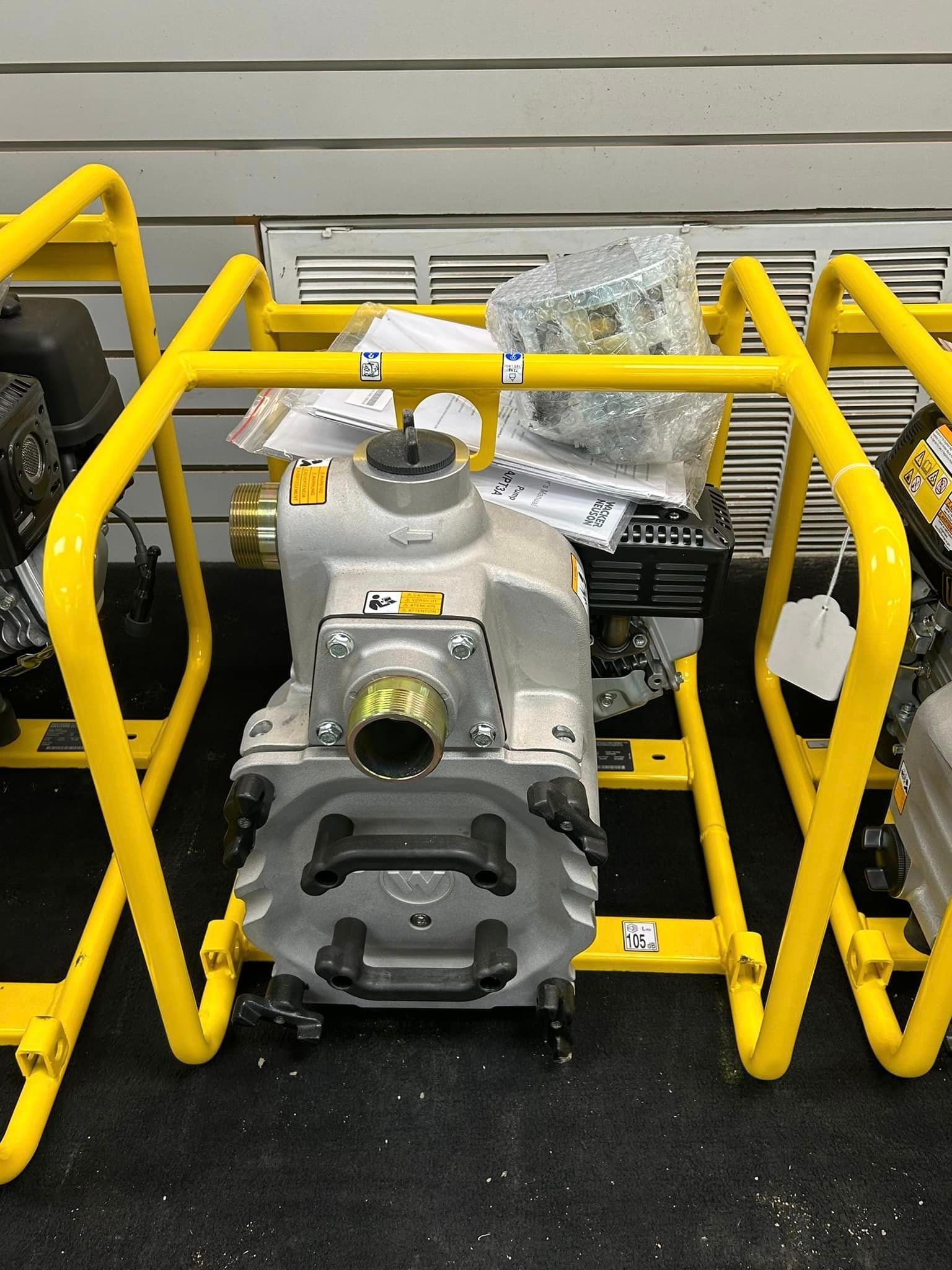 A water pump is sitting on top of a yellow stand.