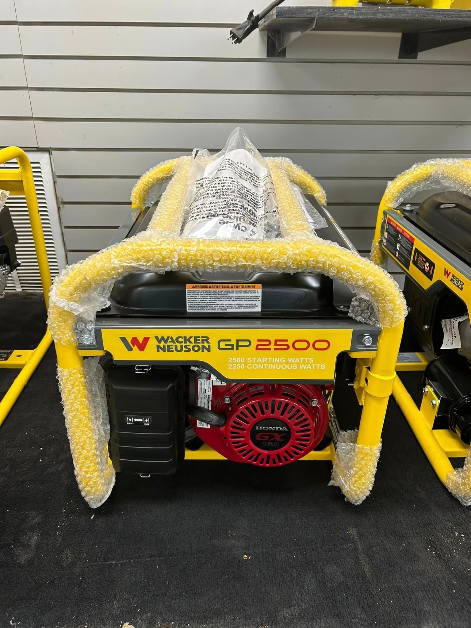 A yellow generator is sitting on top of a black carpet.