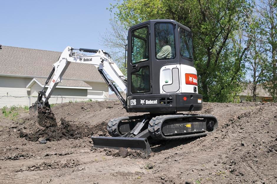 A bobcat excavator is digging a hole in the dirt
